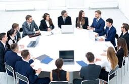 Executives sitting around a round white table